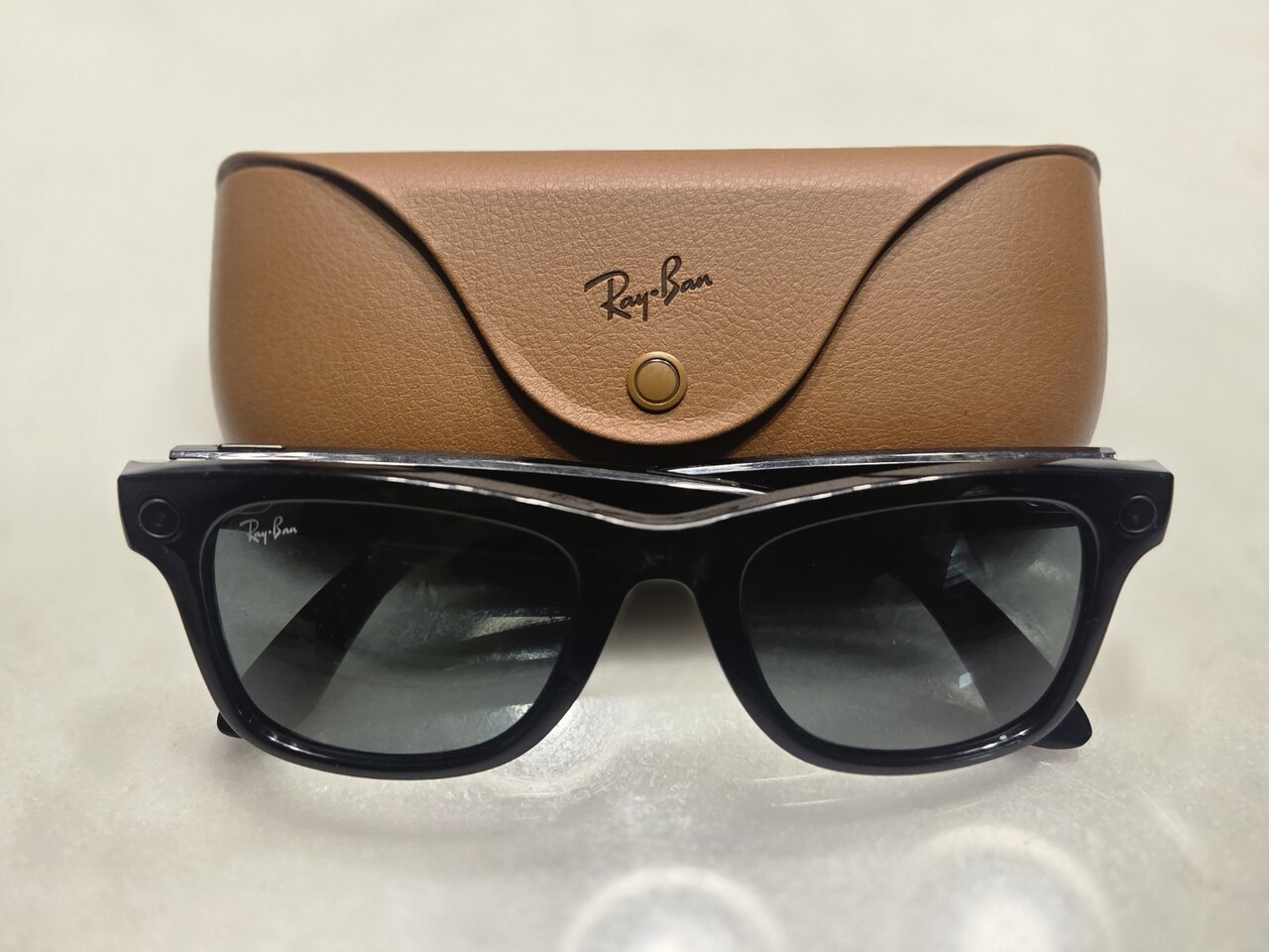 Ray-Ban Meta smart glasses resting beside their charging case